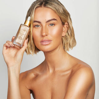 Woman holding a skincare product against a neutral background